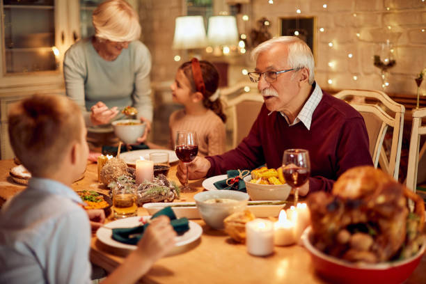 istock Grandfather and grandson communicating during Thanksgiving dinner at dining table. 1349700817