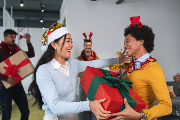empresarias de etnia asiática y afroamericana disfrutando de la fiesta de navidad en la oficina - businessman 30s low key surprise fotografías e imágenes de stock