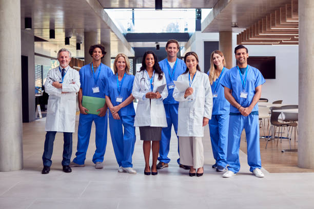 Portrait Of Multi-Cultural Medical Team Wearing Uniform Standing Inside Hospital Building stock photo