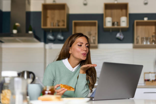 istock Young woman doing a video call on her laptop during breakfast 1349706545