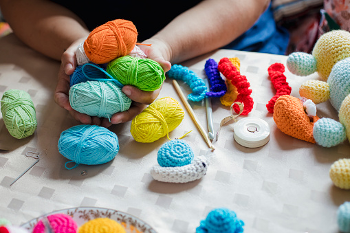 Close up of balls of wool and crocheting tools a woman is using to make products to sell in her store in the North East of England.
