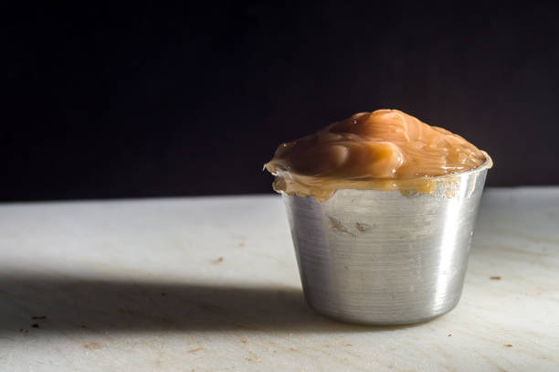 dulce de leche, in a small pot on a white plate, selective focus