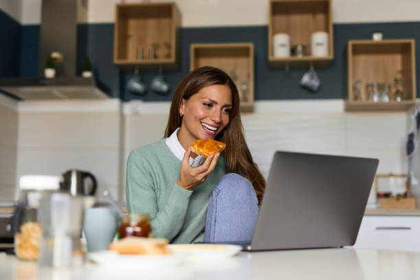 istock Young woman doing a video call on her laptop during breakfast 1349708419