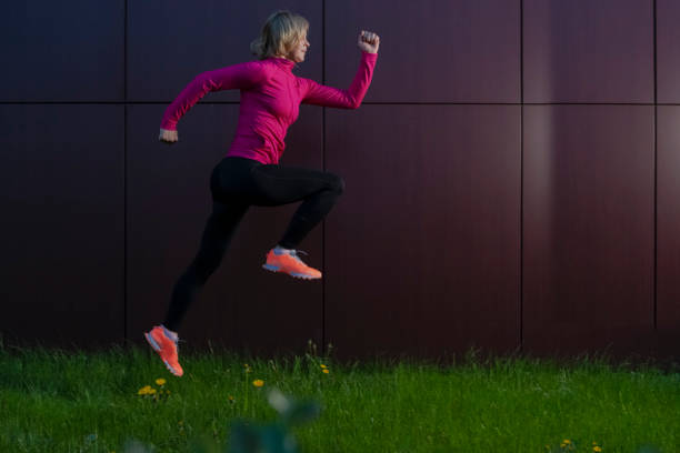 istock Jogging Concepts. Active Mature Sportswoman During Outdoor Active Jogging Training Against Abstract Wall Background. Horizontal Image Composition 1349714880
