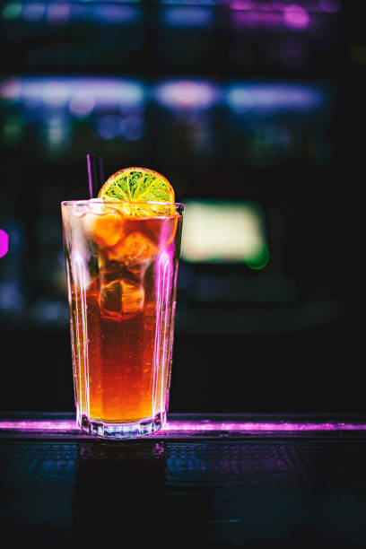 glass of long island ice tea cocktail at bar counter background. glass of long island ice tea cocktail at bar counter background. cuba libre stock pictures, royalty-free photos & images