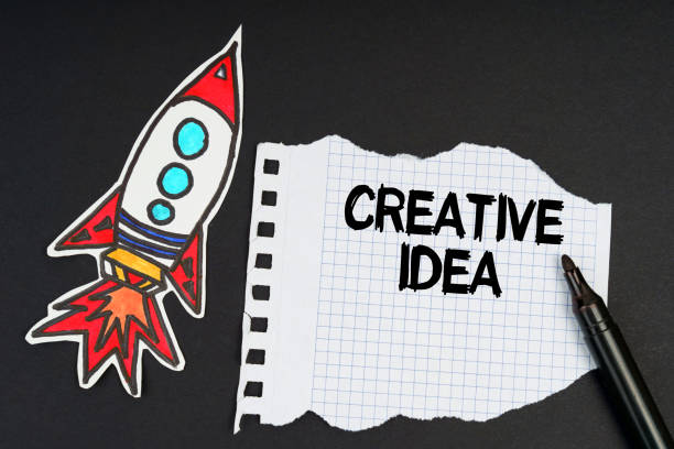 istock On a black background, a rocket, a marker and paper with the inscription - CREATIVE IDEA 1349717420