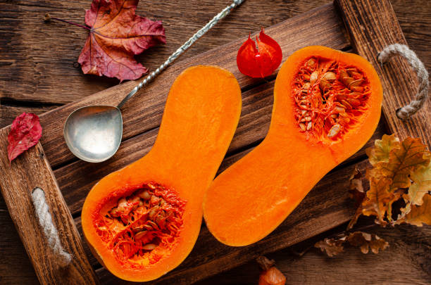istock Halved pumpkin on rustic wooden tray. 1349717515
