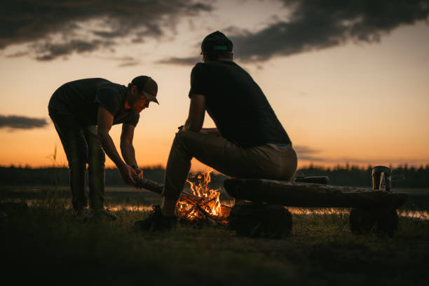 istock Friends preparing bonfire on a lakeshore. Summer sunset 1349726966