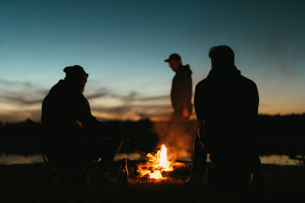 Group of friends by the fire. Forest trip