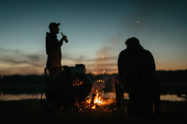 istock Friends burning bonfire on a lakeshore. Summer sunset 1349728715