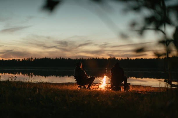 istock Friends burning bonfire on a lakeshore. Summer sunset 1349728716