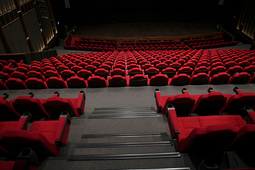 Shot of empty red seats in movie theater. Horizontal shot.