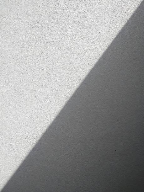 istock White concrete wall background with black shadows running in straight lines. Two-tone style. 1349752070
