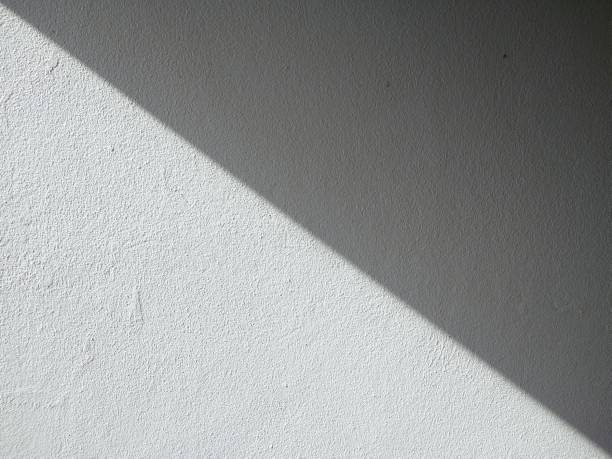 istock White concrete wall background with black shadows running in straight lines. Two-tone style. 1349752092