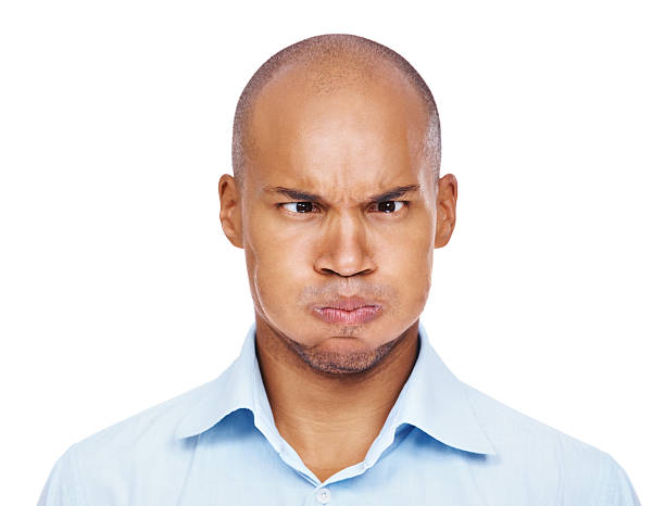 Closeup of a young African-American man squinting his eyes and puffing out his cheeks