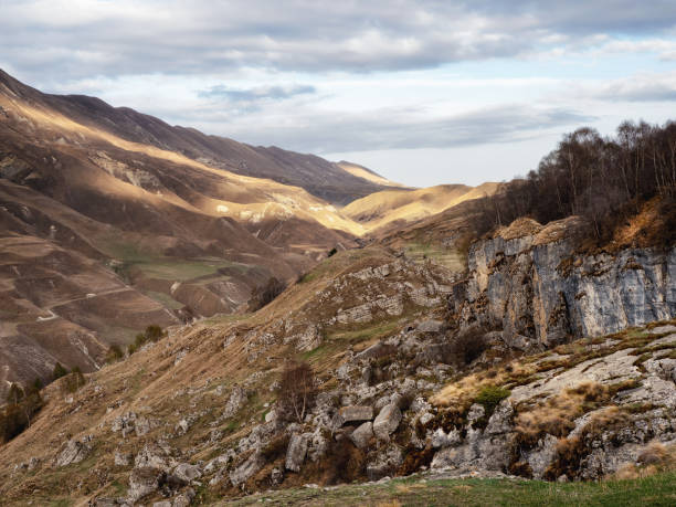 istock Dramatic alpine scenery with high mountain valley in sunlight and in shadow under cloudy sky. Scenic mountain landscape with changeable weather in highlands. Sunny and overcast. Sunlight and shadow 1349756148