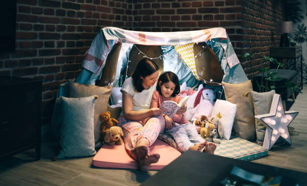 istock Mother and daughter having a pajama party reading a book 1349756584