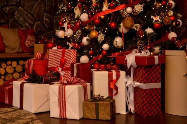 Red and white boxes with gifts near the christmas tree.Christmas background