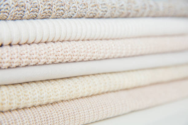istock A stack of beige things, clothes of different textures. Fabric texture, background in pastel colors. Natural fabric, wool. Selective focus. 1349767729