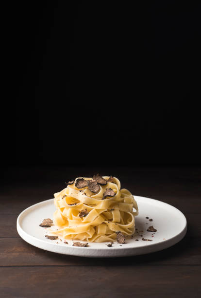 tagliatelle pasta with black truffle mushrooms. tagliatelle al tartufo - italian autumn fresh recipe with black truffle, rustic style, copy space - truffle tuber melanosporum mushroom 個照片及圖片檔