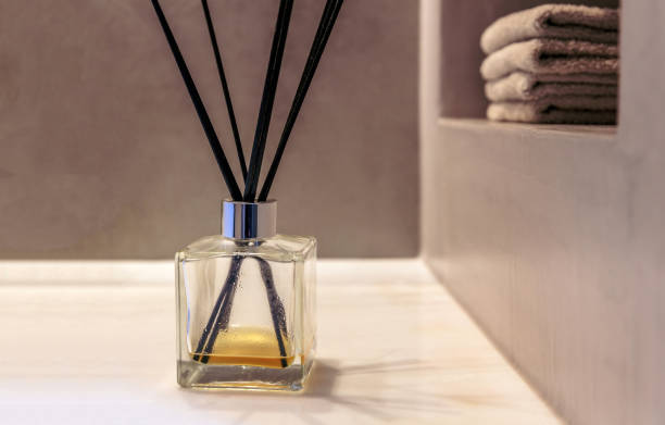 istock Reed diffuser in a bathroom, black sticks in a glass bottle, modern design spa interior detail. 1349773069