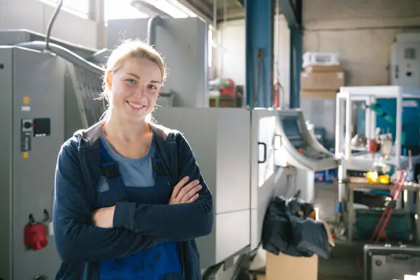 Portrait of a young female trainee in manufacturing factory