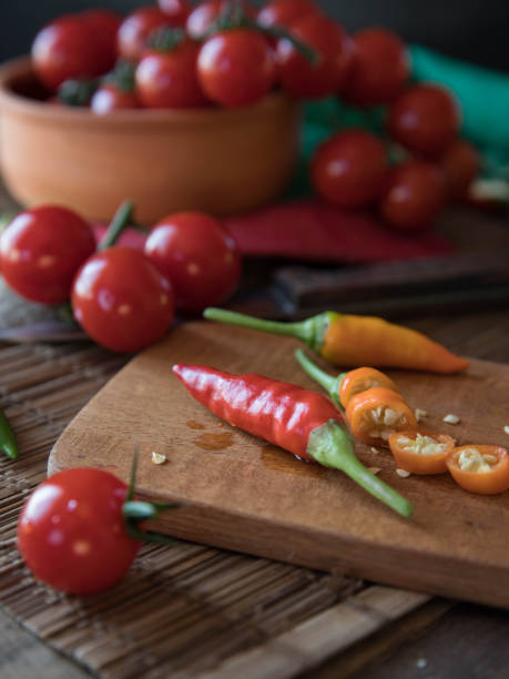istock Tomatoes and chili pepper on a chopping board. 1349785936