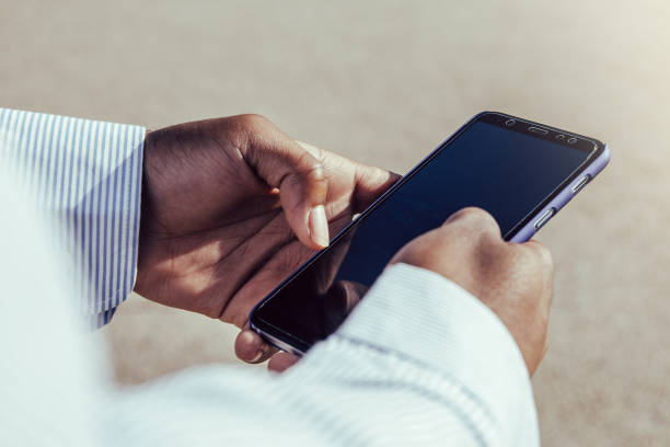 istock Very close-up view of afro hands using mobile phone outdoors. 1349788739