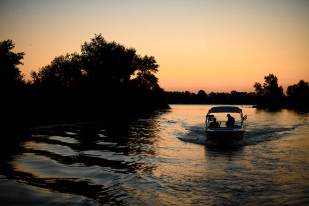 великолепный вечерний вид на реку, по которой плывет моторная лодка - wakeboarding waterskiing water ski sunset стоковые фото и изображения