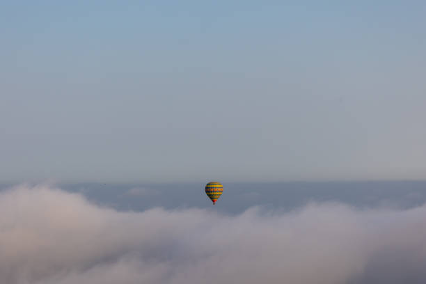 istock Hot air balloon on over the clouds before sunset time 1349792104
