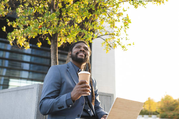 istock handsome man with laptop and coffee in the park working, relaxed, 1349792306