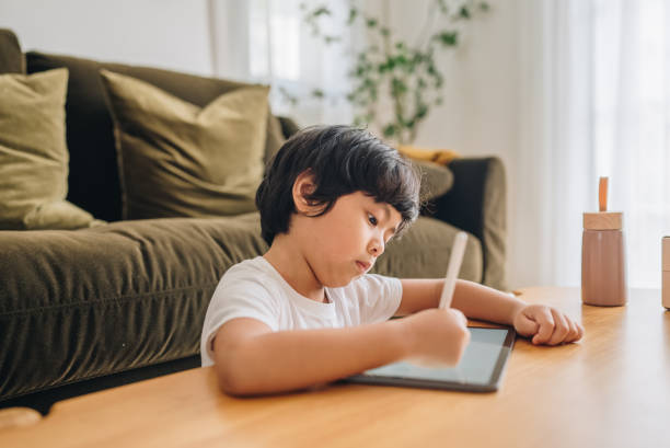 istock Asian boy digital artist paints on a graphic tablet. 1349793372