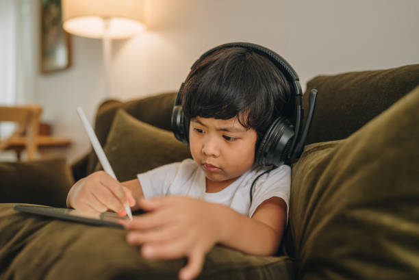 istock Asian boy digital artist paints on a graphic tablet. 1349795374