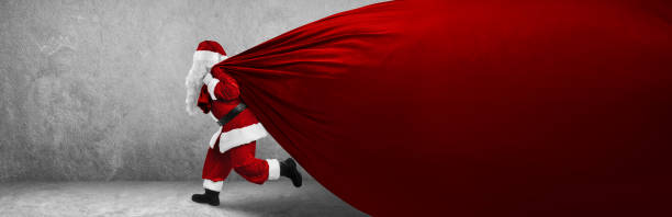 istock Santa Claus Pulling Huge Bag Full Of Christmas Presents 1349797642