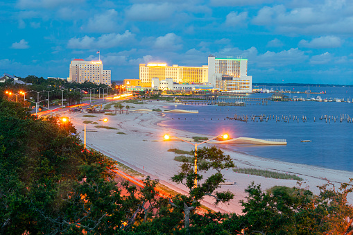 Biloxi, Mississippi, USA - July 1, 2021: Casinos and beach on Biloxi Bay at sunset.