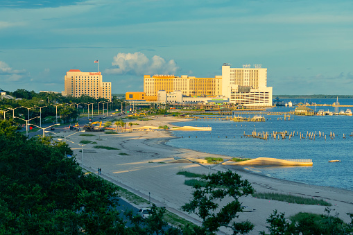 Biloxi, Mississippi, USA - July 1, 2021: Casinos and beach on Biloxi Bay at sunset.