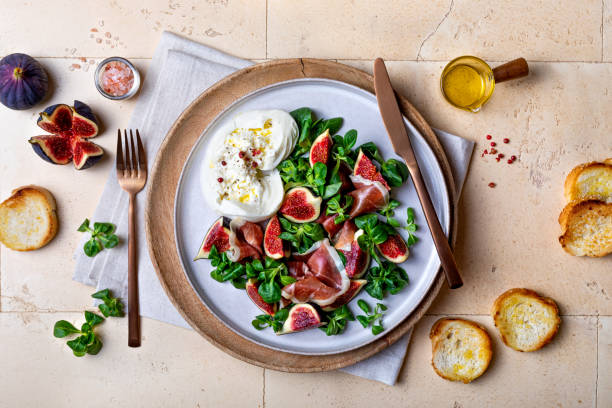 Fig salad with prosciutto,  green leaves mix,  burrata cheese and toasted bread. Top view, overhead, flat lay Fig salad with prosciutto,  green leaves mix,  burrata cheese and toasted bread. Top view, overhead, flat lay prosciutto stock pictures, royalty-free photos & images