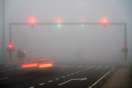 Early in the morning on the road you have these traffic lights in the thick fog