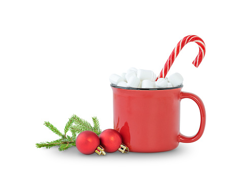 Christmas beverage in a red cup with marshmallow, candy and Christmas ornaments isolated on white