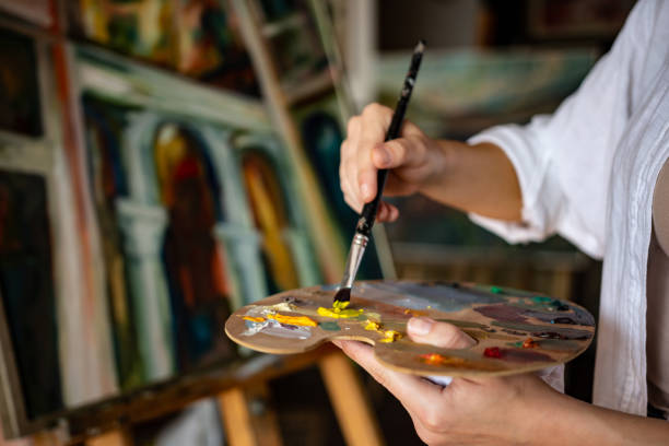 istock Female painter using color palette and a paintbrush 1349806726