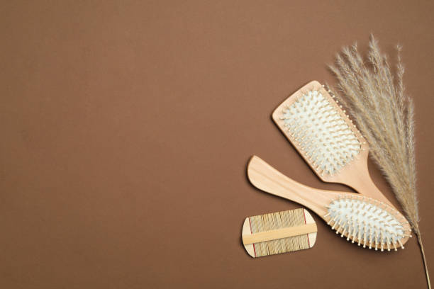 istock Flat lay composition with modern hair comb and brushes on brown background. Space for text 1349806831