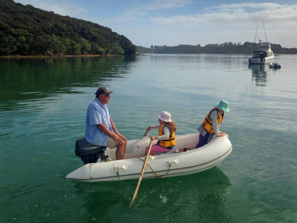 Rowing Lesson - a grandfather teaching two grandchildren how to row, in an inflatable dinghy, Bay of Islands, New Zealand