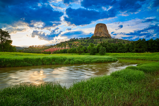 Sunset at Devils Tower National Monument with the Belle Fourche River in the foreground.