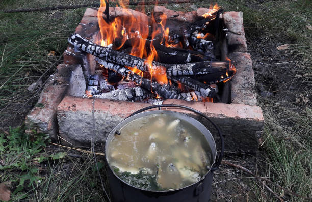 istock Fish soup cooked over a fire, cooked in a saucepan near a fired up grill lined with bricks 1349809991