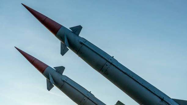 istock Two combat missiles aimed at the sky. Old ballistic missile launcher on blue sky background. 1349811069