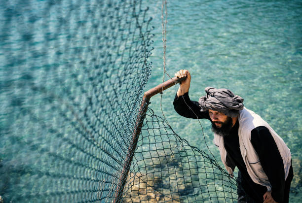 istock Refugee man standing behind the fence 1349813146
