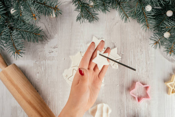 istock Step-by-step Christmas stars cold porcelain garland tutorial. Step 14: Punch holes for rope with drinking straw or stick 1349813378