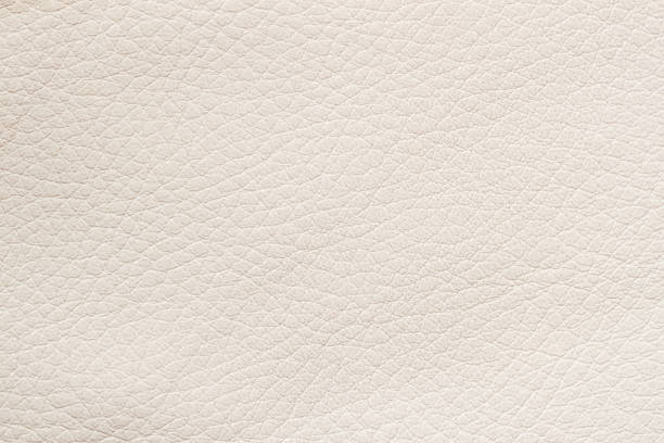 Texture of genuine leather, beige color, background, pattern. Manufacturing of leather accessory concept