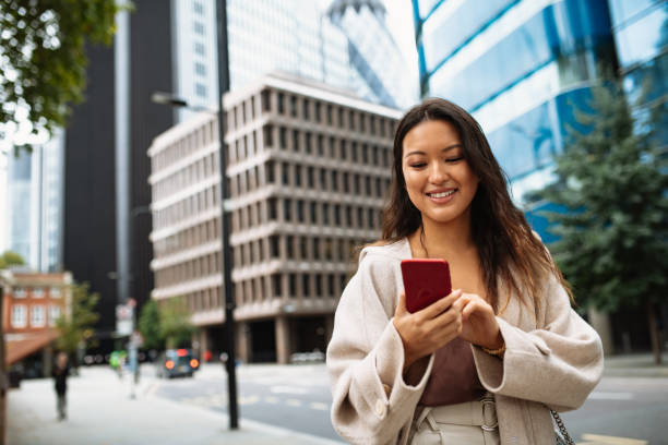 istock Asian woman using phone on the street, sending text messages 1349815522