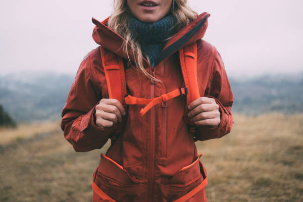 unkenntliche wandererin in roter jacke und mit rucksack an einem bewölkten tag die berge erkunden - meadow autumn hiking mountain stock-fotos und bilder